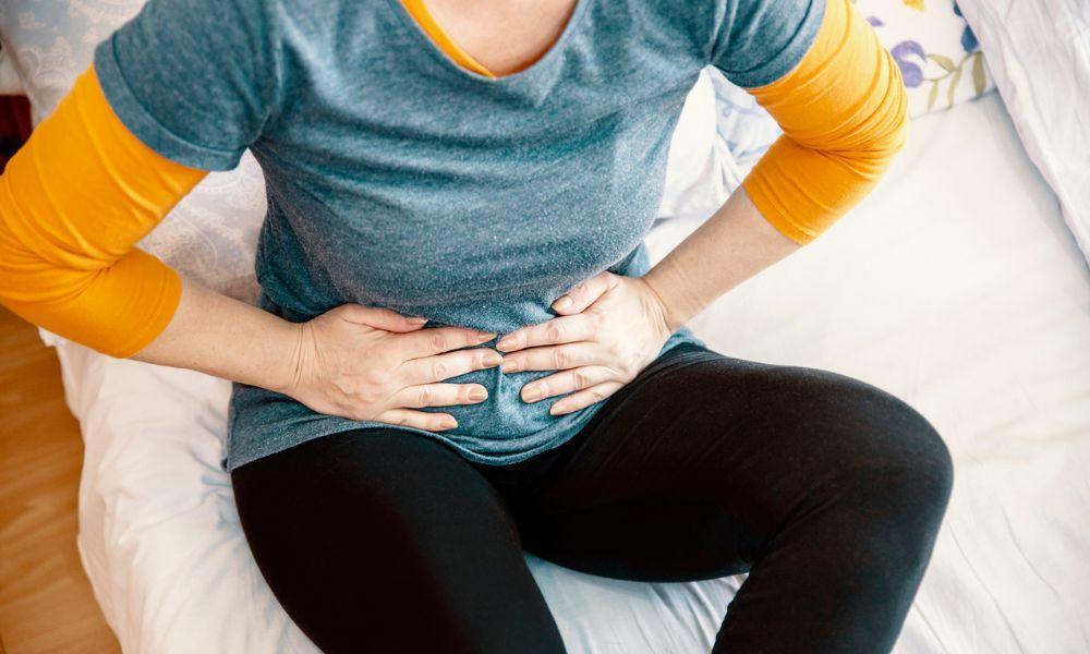 a woman holding her stomach in pain