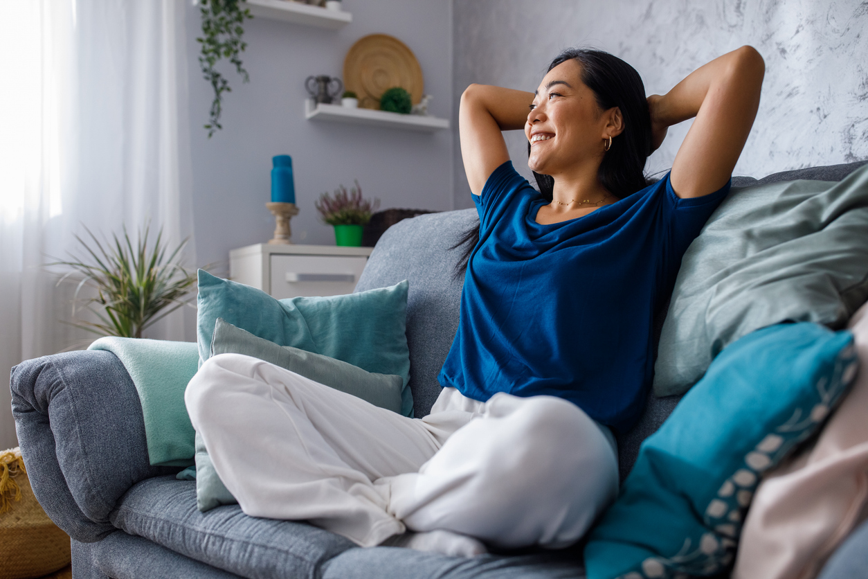 a woman relaxing on her couch at home taking time to herself